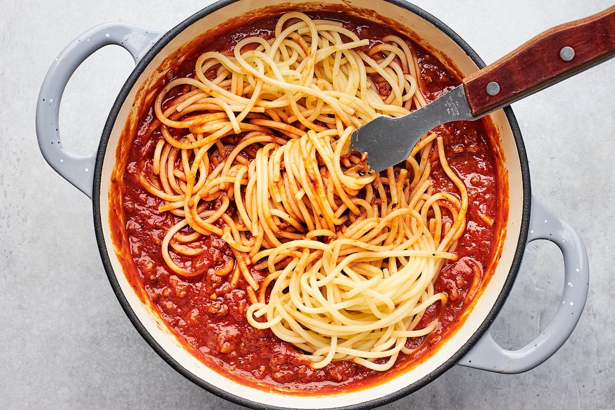 spaghetti with meat sauce in large pot with serving fork.