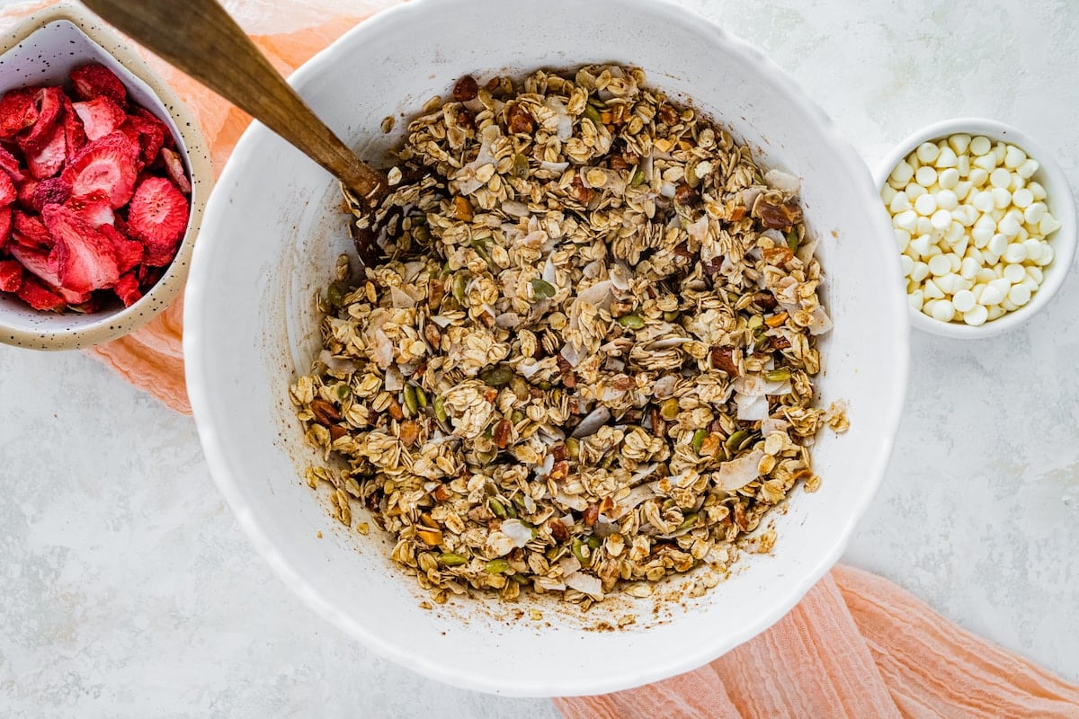 granola being mixed in bowl with spoon.