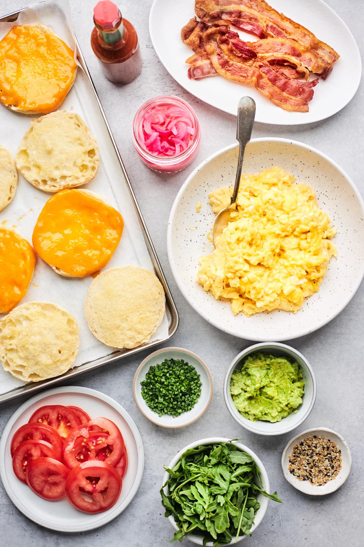 ingredients to make English muffin breakfast sandwiches with scrambled eggs.