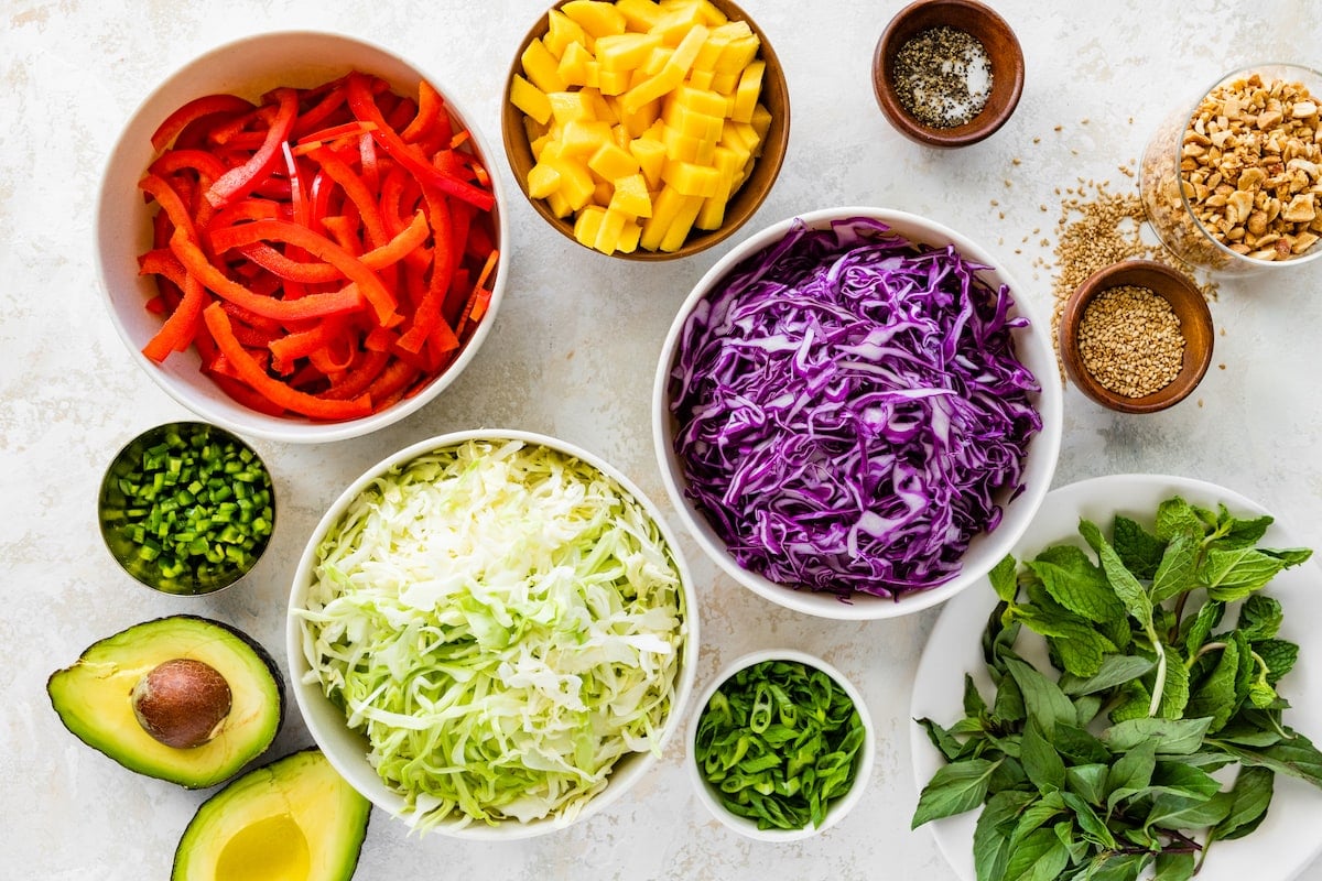 cabbage salad ingredients in bowls.