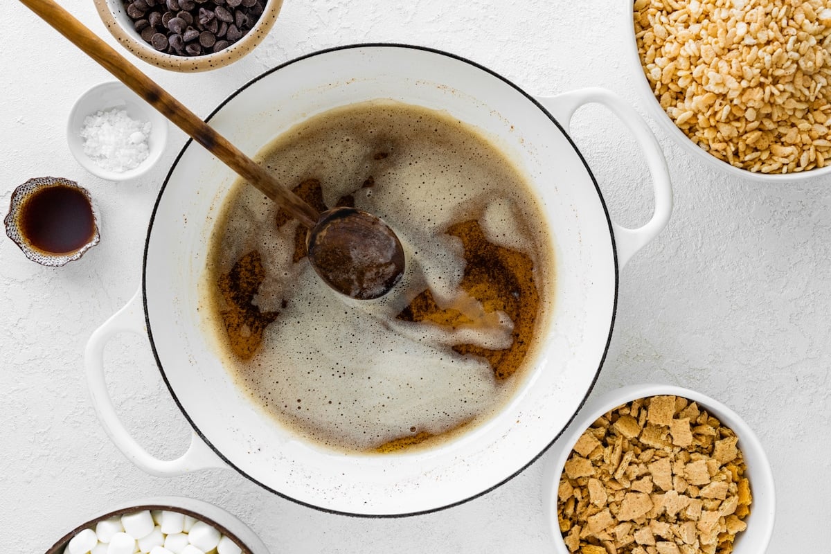 brown butter in white pot with wooden spoon.