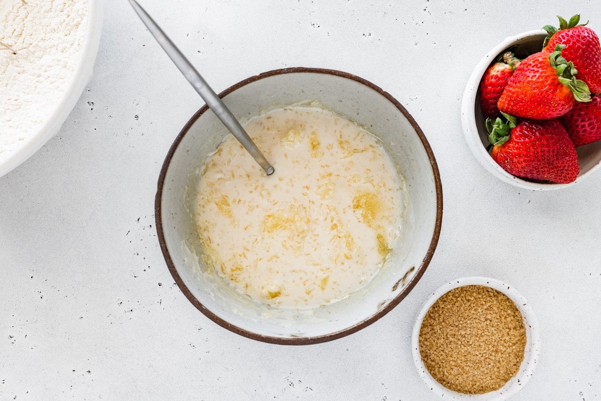 melted butter and buttermilk being mixed together in bowl to make drop biscuits.
