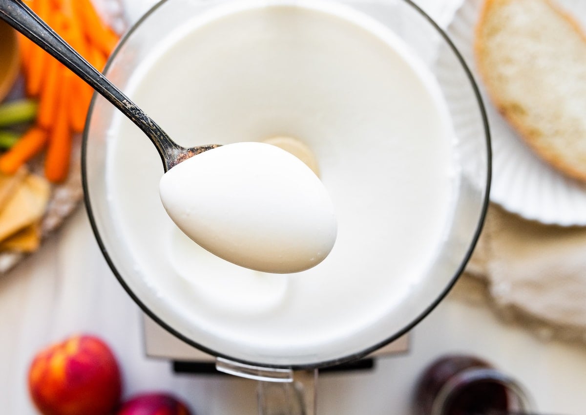 whipped cottage cheese on spoon after being whipped in food processor.