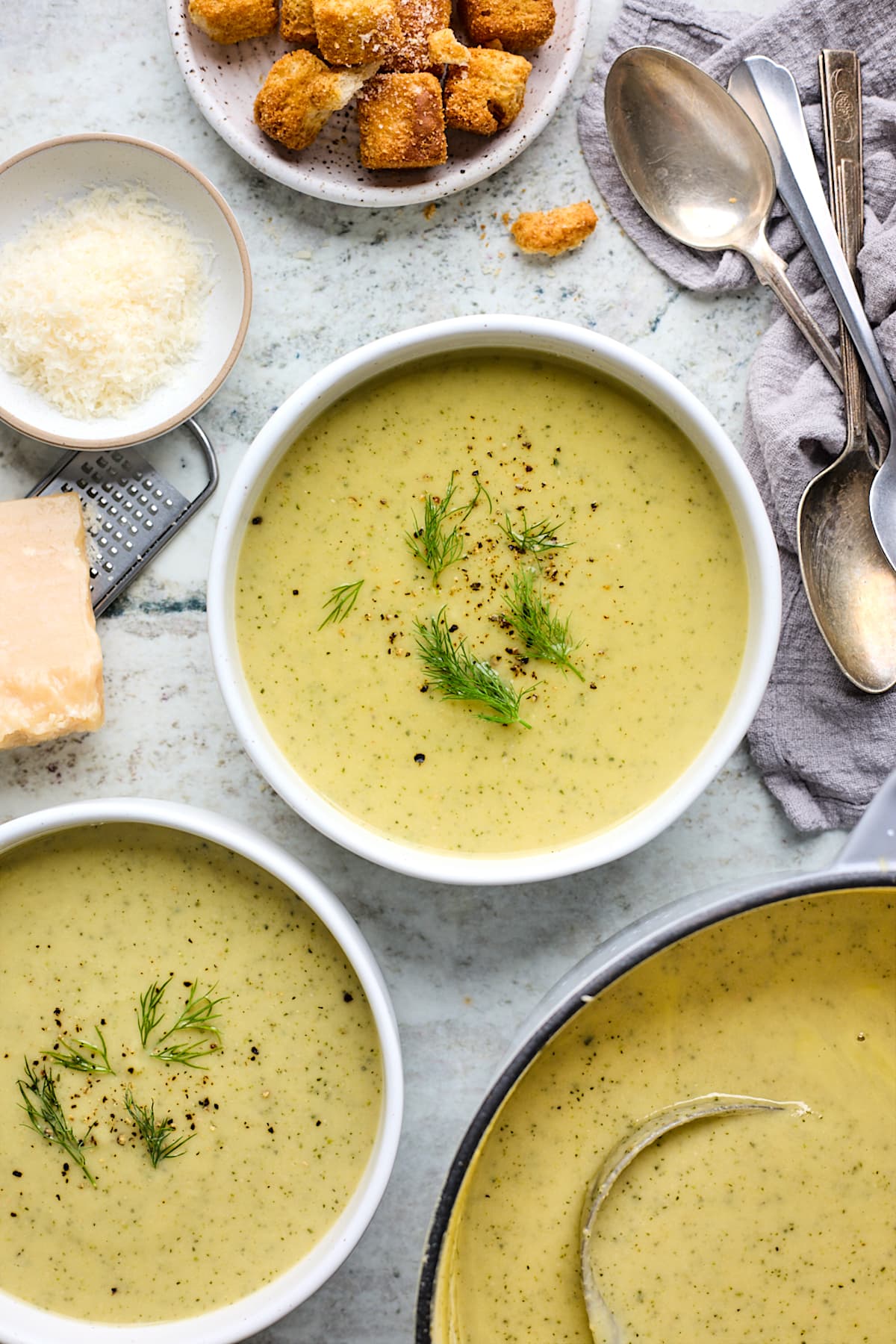 zucchini soup in bowls with black pepper and dill.