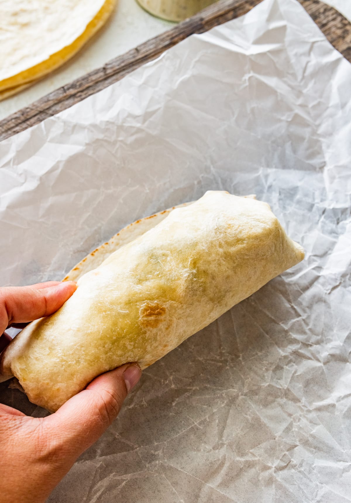 rolled up chicken caesar salad wrap in tortilla.