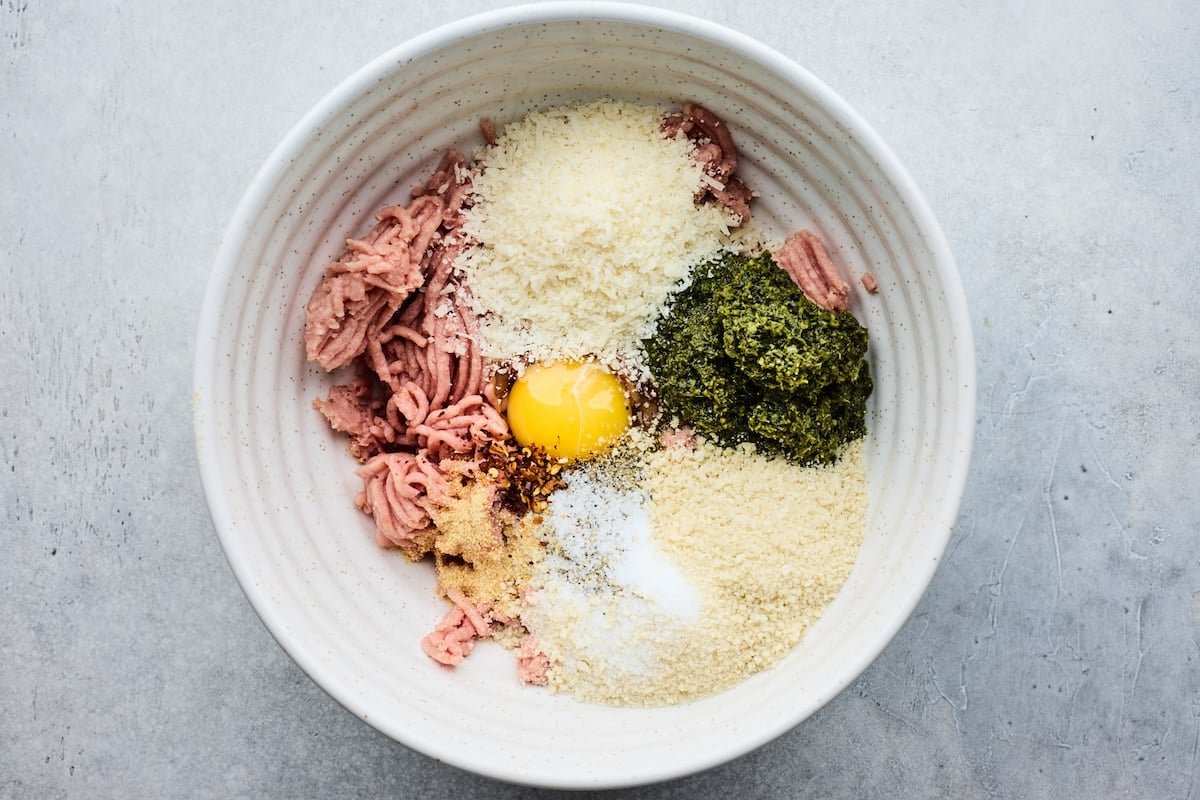 ground turkey, panko, Parmesan cheese, pesto, egg, garlic powder, and crushed red pepper flakes in mixing bowl to make pesto meatballs.