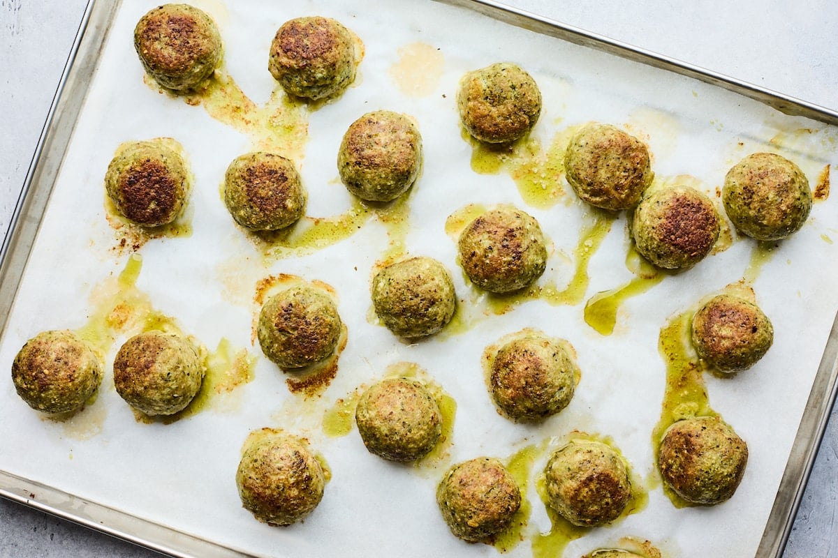pesto meatballs on large baking sheet lined with parchment paper.