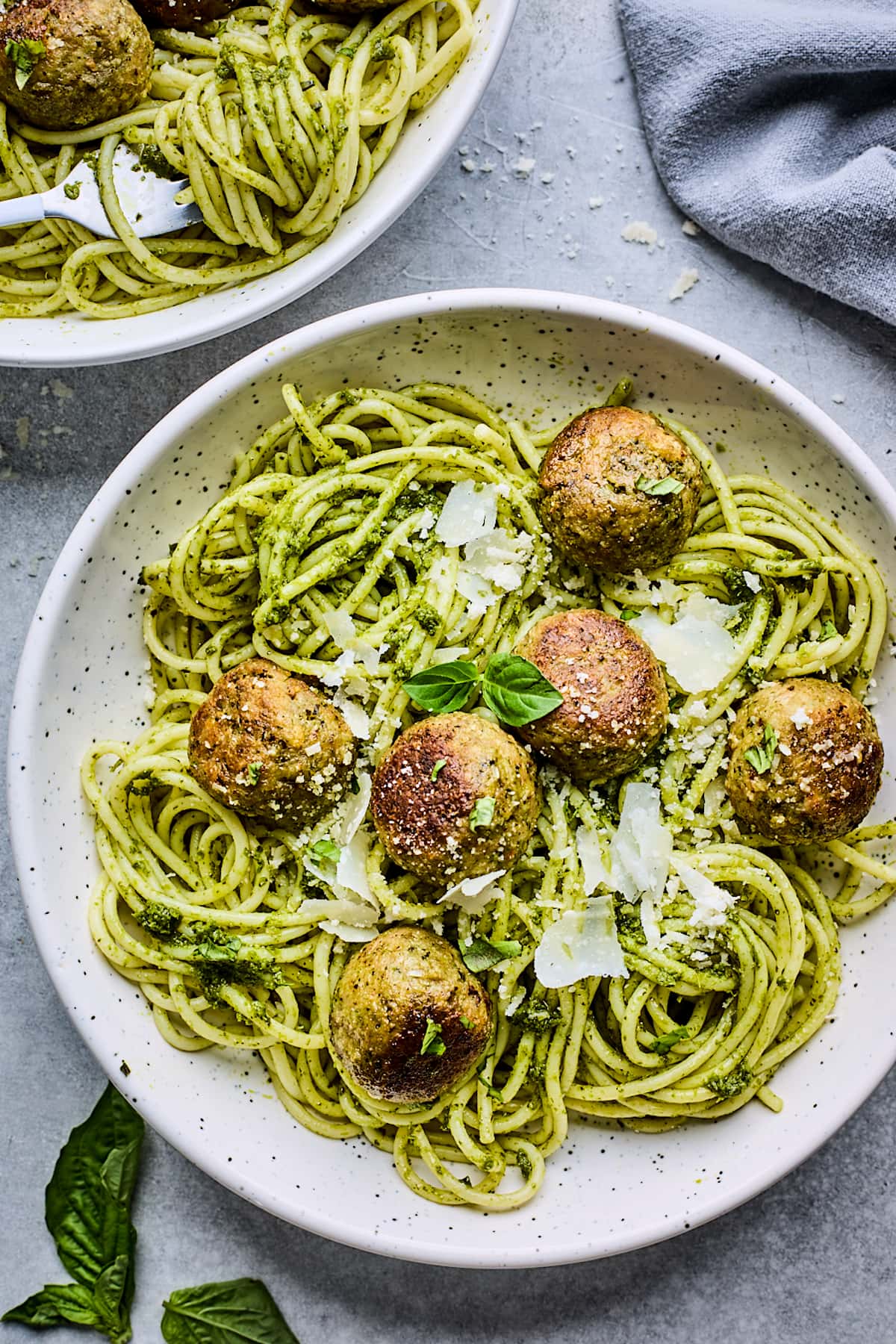 pesto meatballs with pasta and parmesan cheese in bowl.