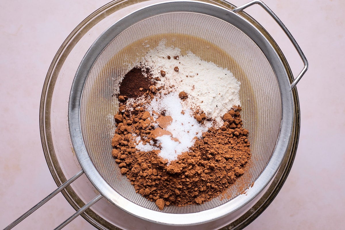 dry ingredients being sifted into mixing bowl to make raspberry brownies.