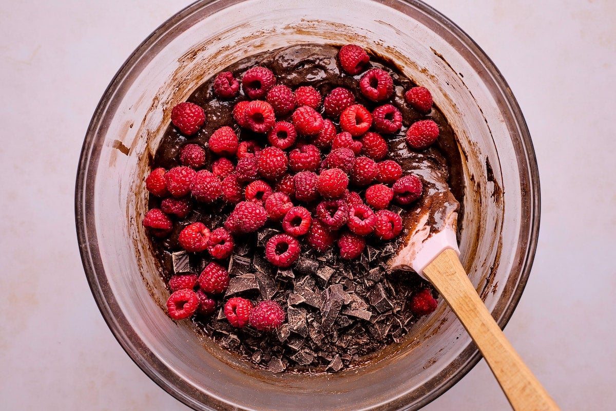 raspberry brownie batter in mixing bowl with spatula.