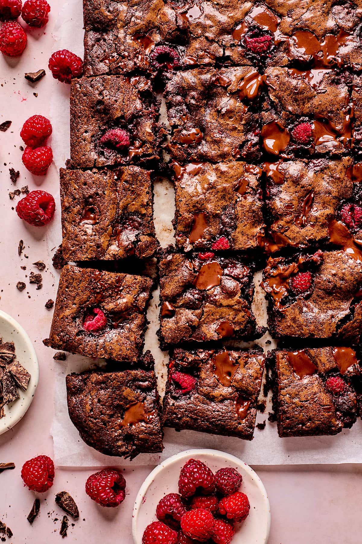raspberry brownies cut into squares with fresh raspberries.