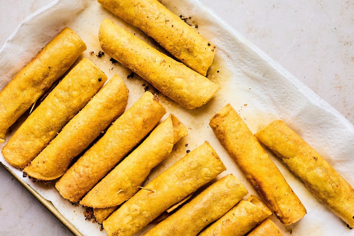 beef taquitos on tray with paper towels.