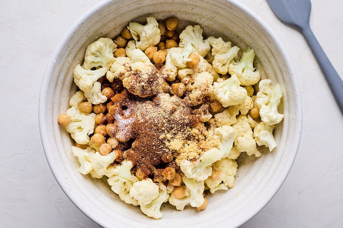 cauliflower, chickpeas, and spices in mixing bowl.
