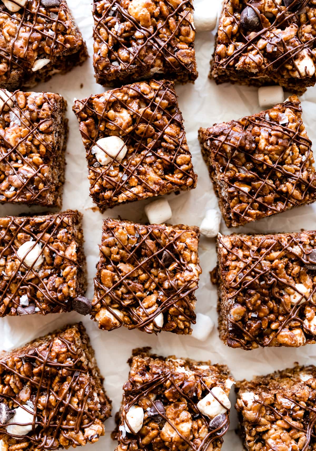 chocolate rice krispie treats cut into squares on parchment paper.