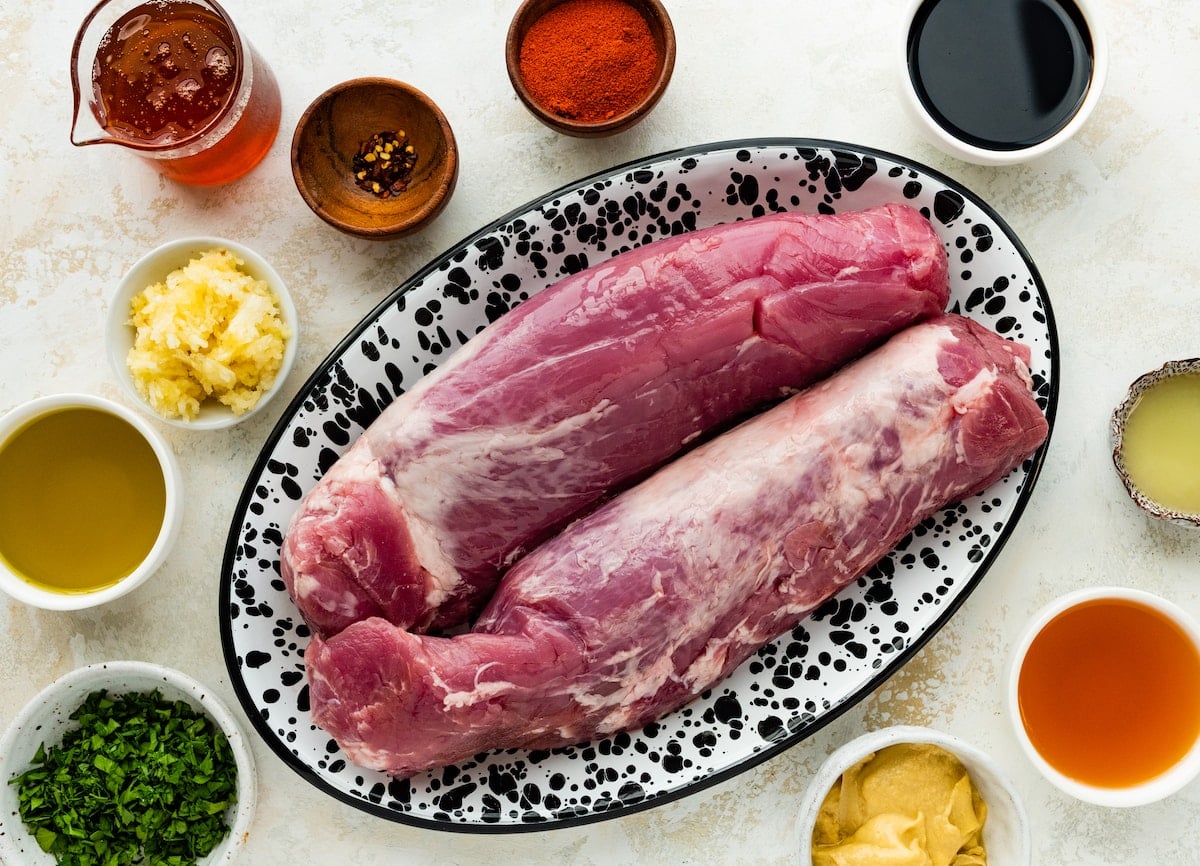 pork tenderloins on plater with marinade ingredients in little bowls.