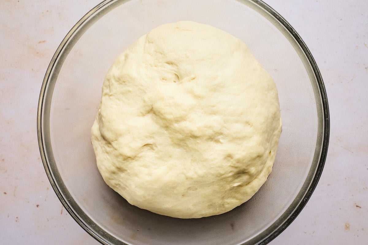 dinner roll dough in bowl after it has risen.