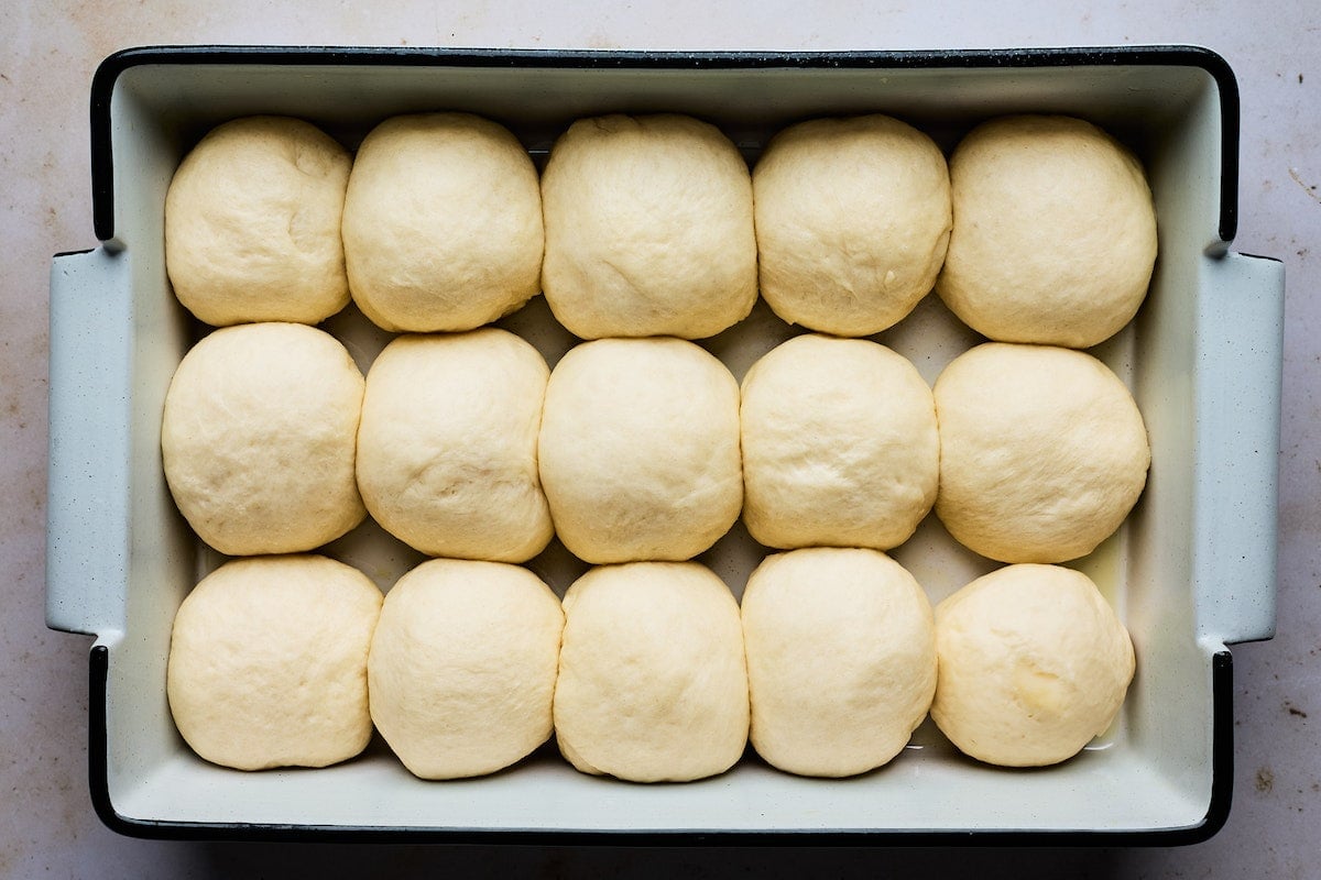 dinner roll dough rising in pan.