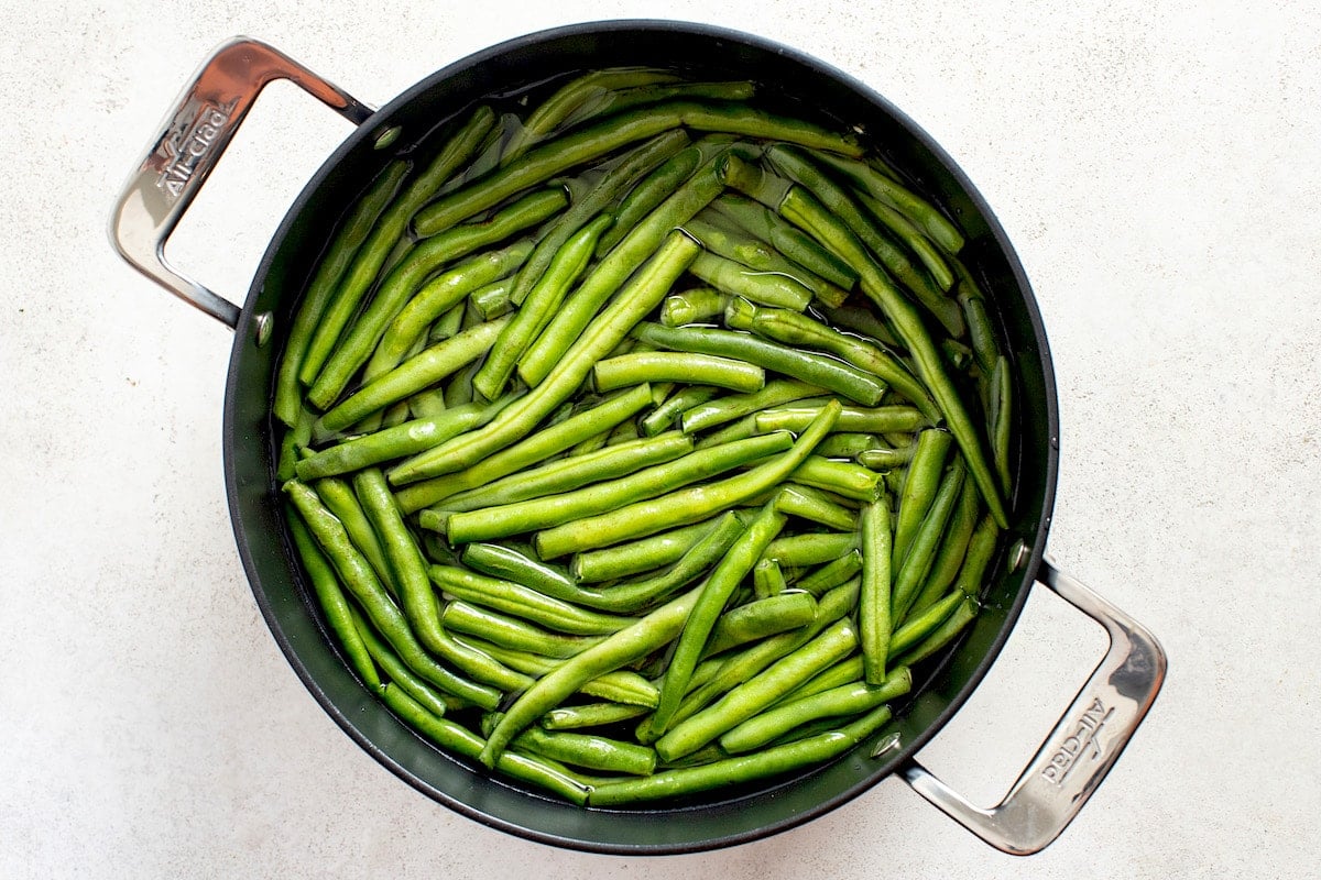 green beans cooking in pan with water.