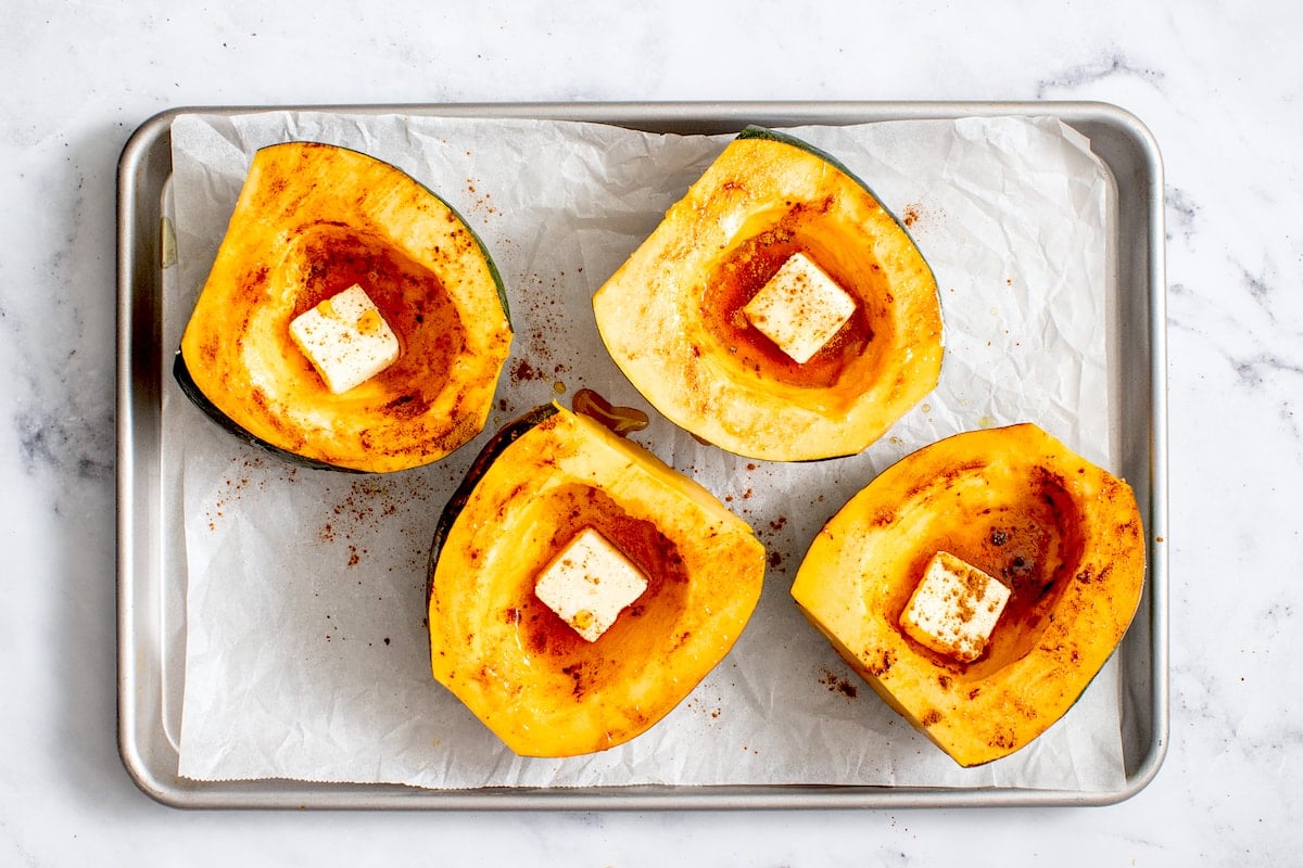 acorn squash halves with butter, maple syrup, and cinnamon.