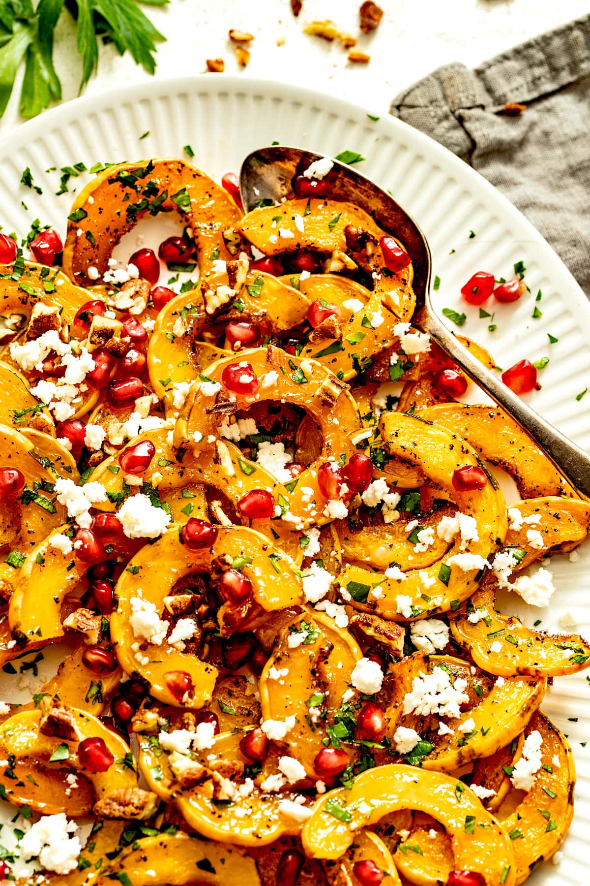roasted delicata squash on platter with spoon.