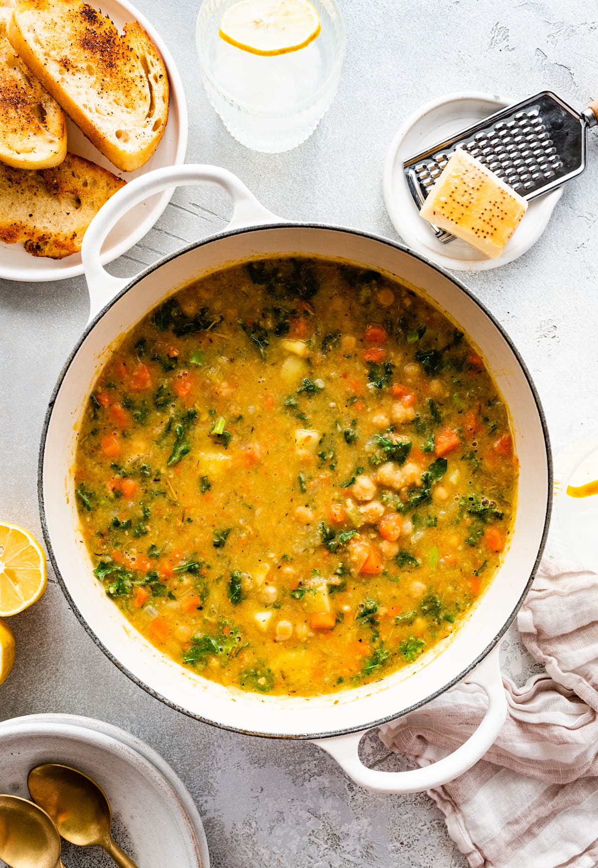 chickpea soup in pot with bread and Parmesan cheese.
