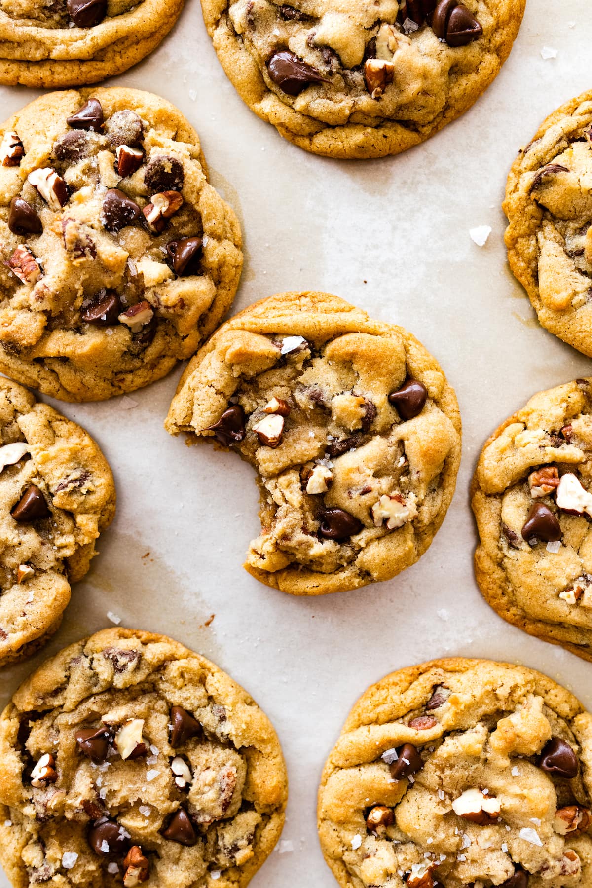maple pecan chocolate chip cookies with one cookie that has a bite out of it.