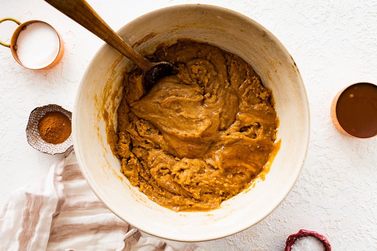 snickerdoodle blondie batter in mixing bowl with wooden spoon.