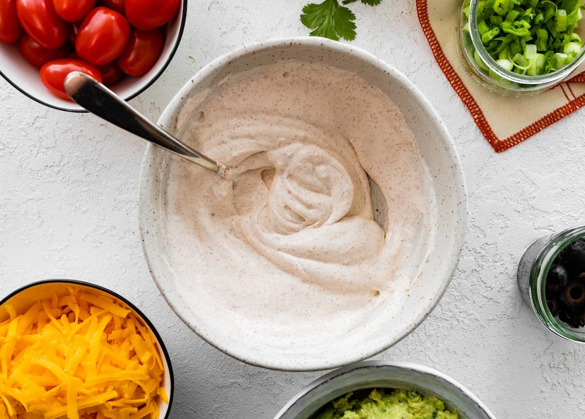 sour cream with taco seasoning in bowl with spoon.