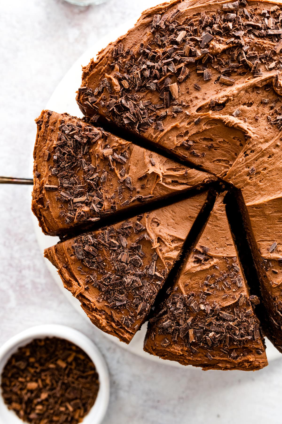 chocolate cake cut into slices with chocolate shavings on top.