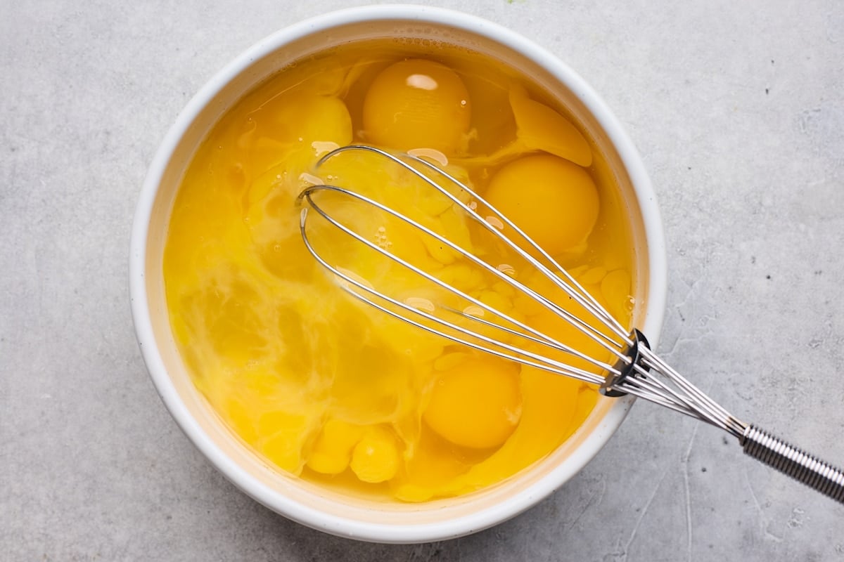 eggs in bowl with whisk.
