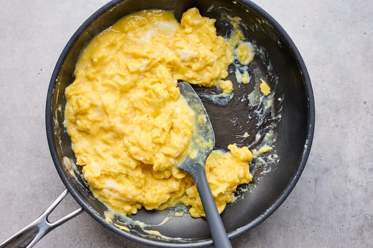 scrambled eggs in skillet with spatula.