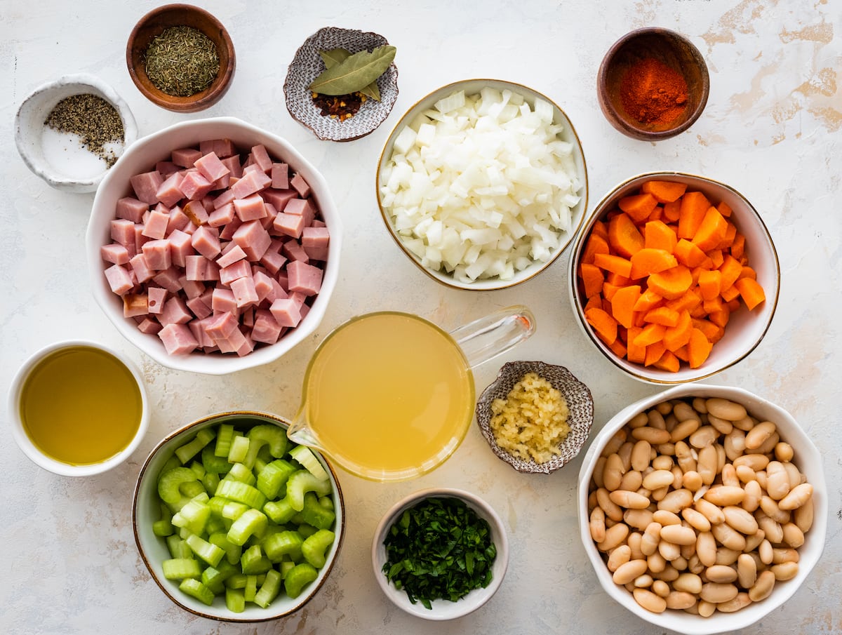 ingredients to make ham and bean soup in bowls.
