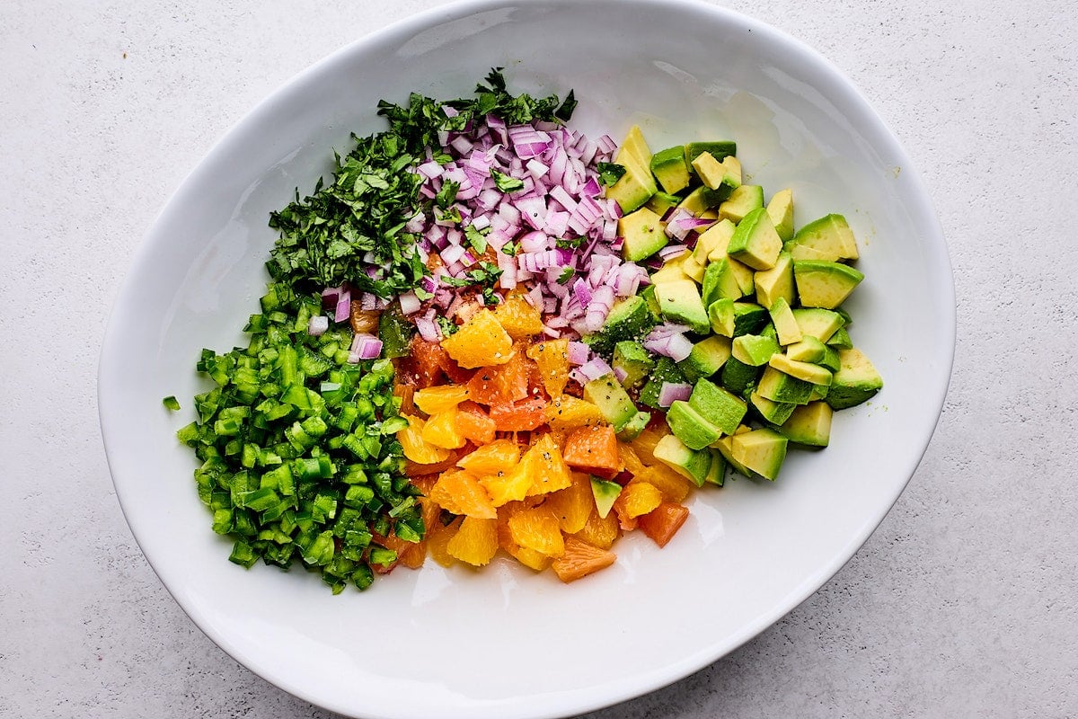 citrus salsa ingredients in large white bowl.