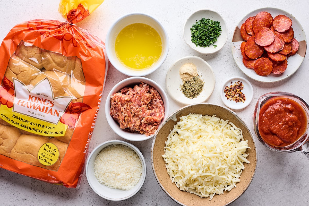 ingredients in bowls to make pizza sliders on Hawaiian sweet rolls.