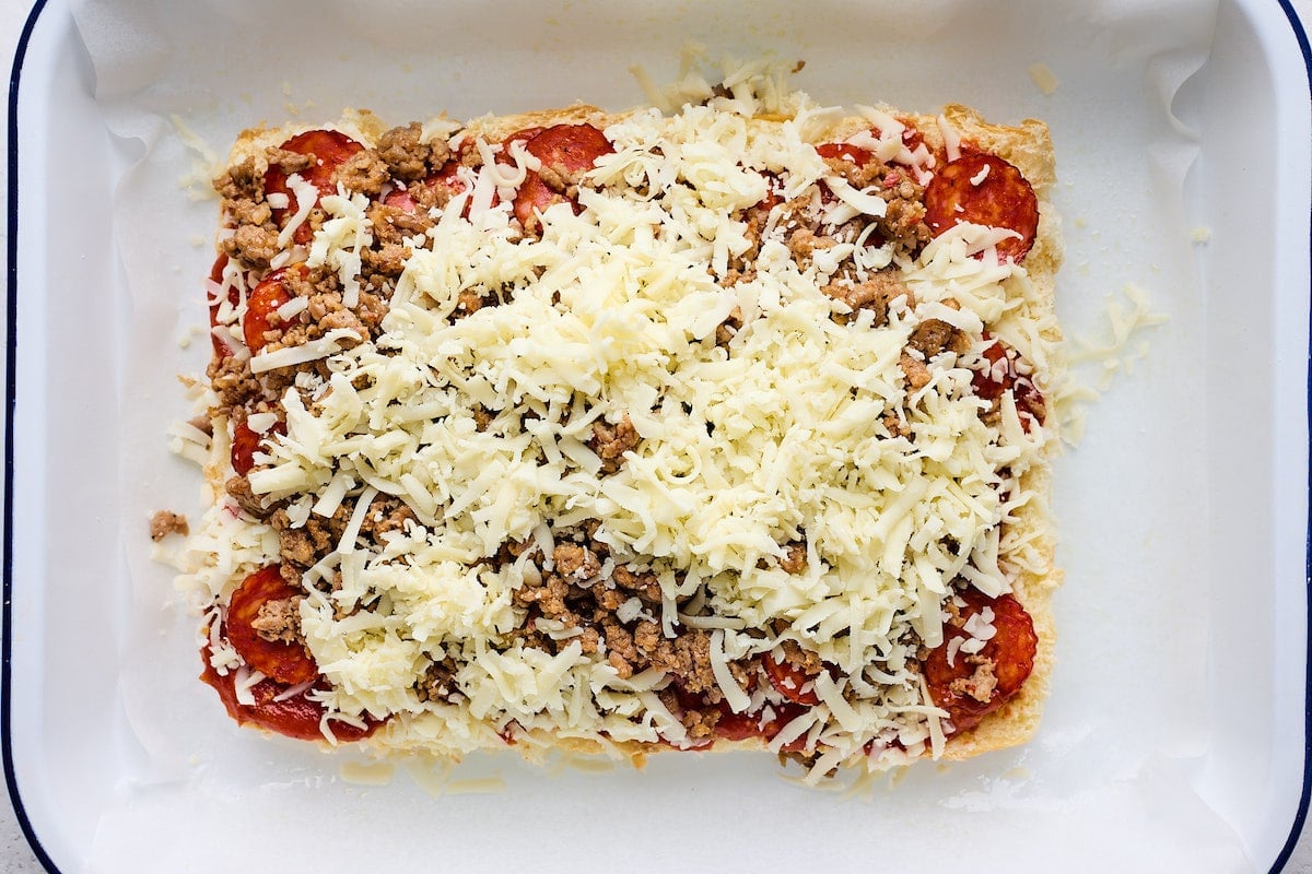 pepperoni, sausage, ad shredded mozzarella cheese on top of Hawaiian sweet rolls to make pizza sliders.
