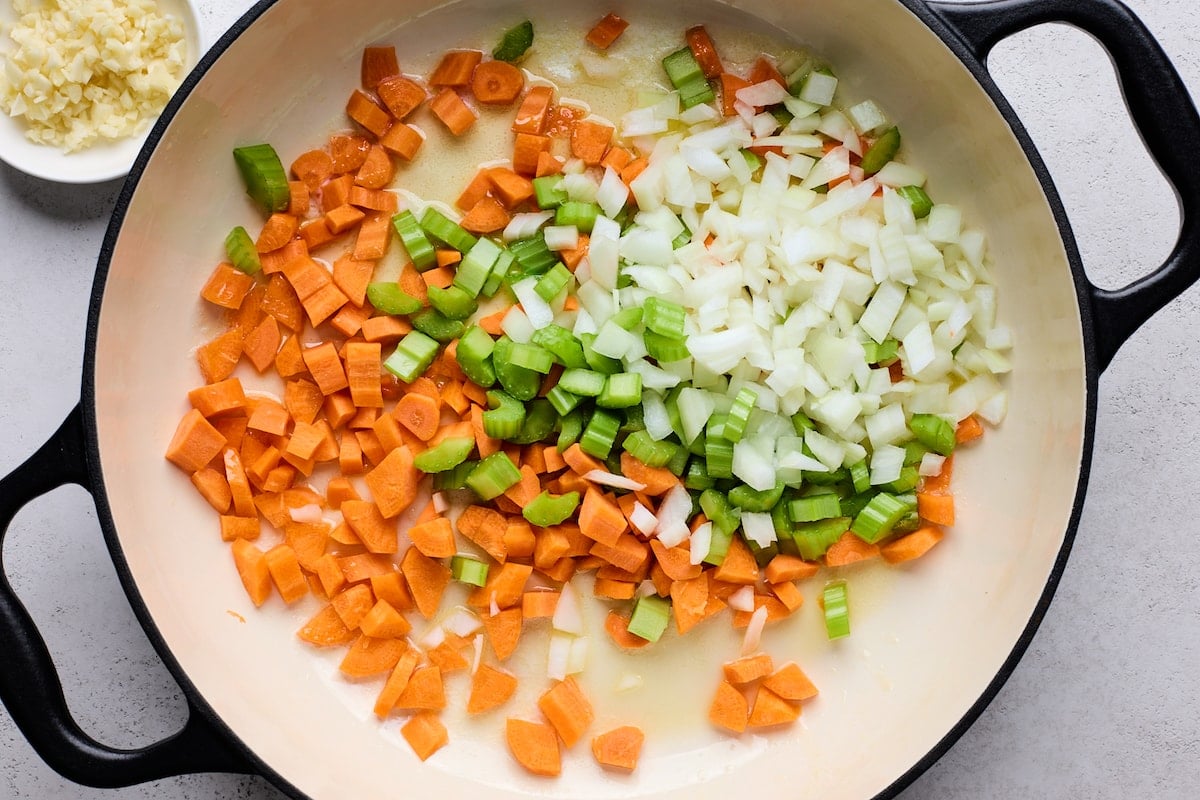 onion, carrots, and celery cooking in skillet to make chicken pot pie with biscuits.