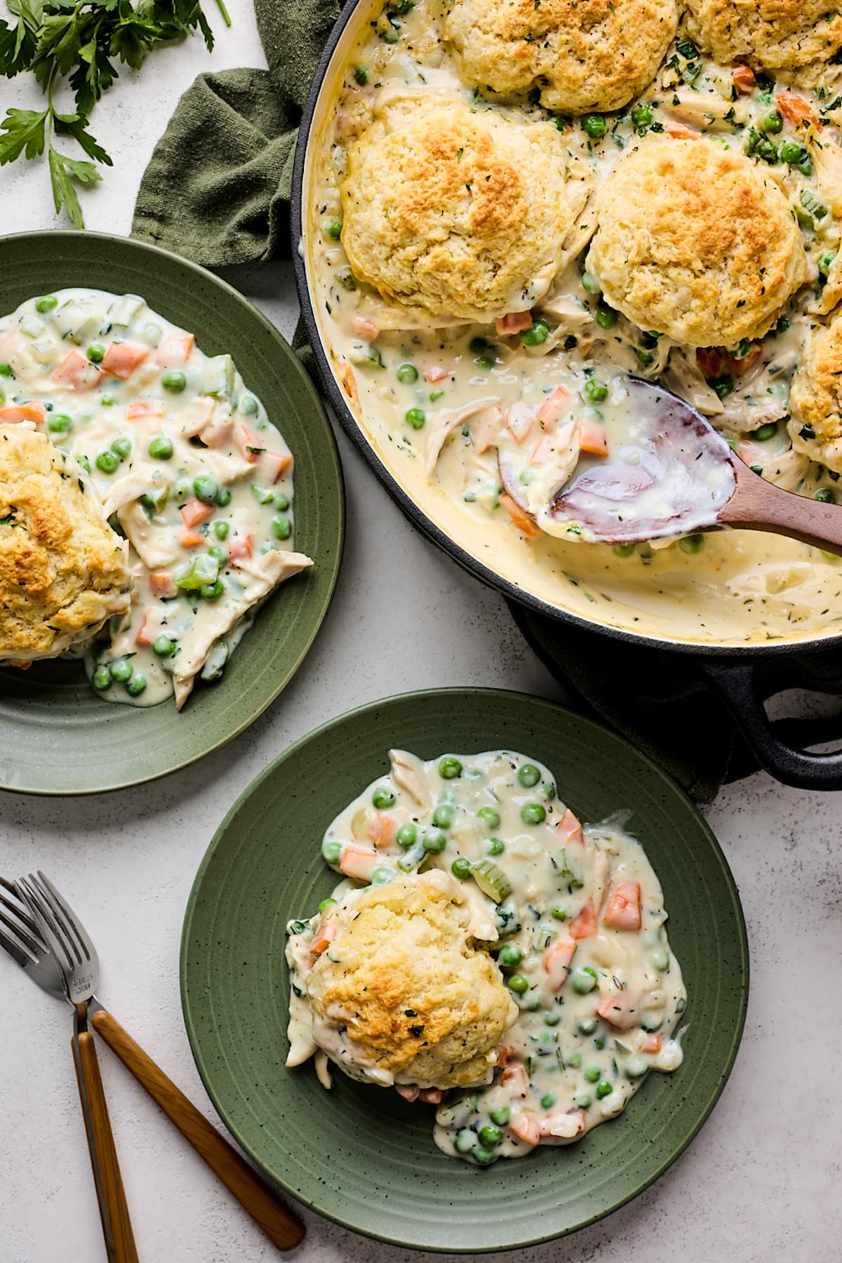 chicken pot pie with biscuits on plates and in skillet.
