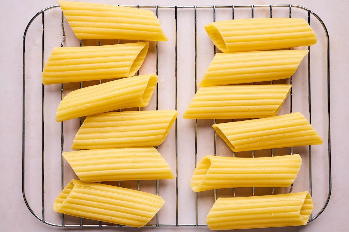 cooked manicotti noodles cooling on rack.