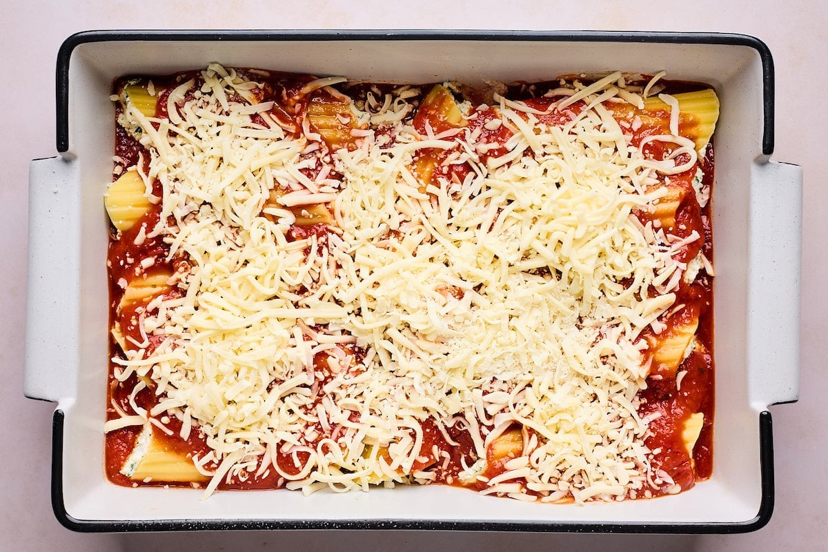 manicotti with marinara sauce and shredded mozzarella cheese in baking dish.
