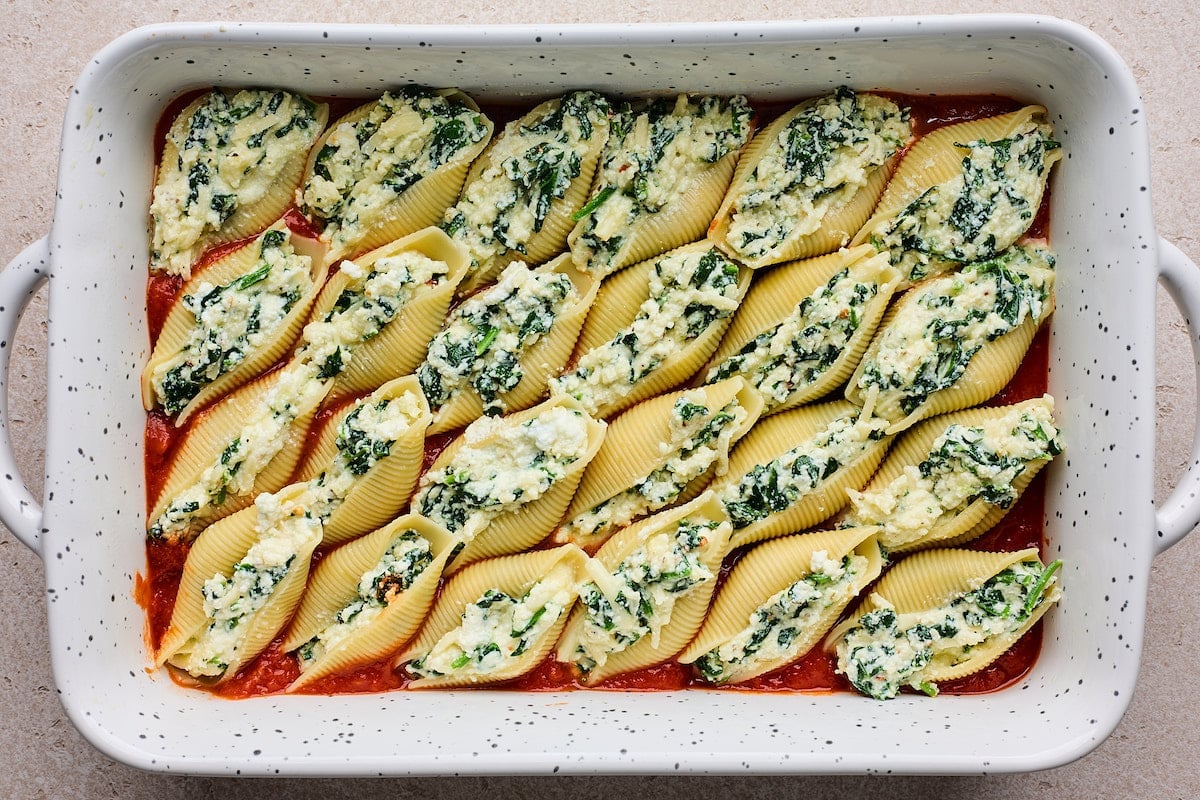 stuffed shells with ricotta spinach filling in baking dish.