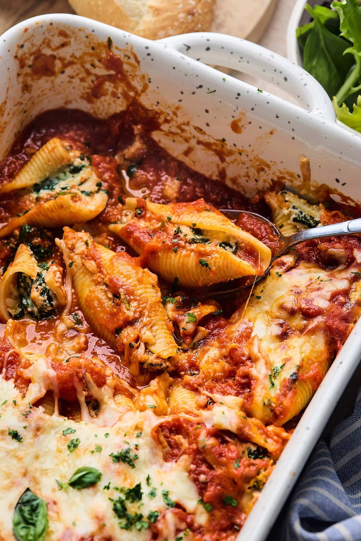 stuffed shells in pan with spoon.