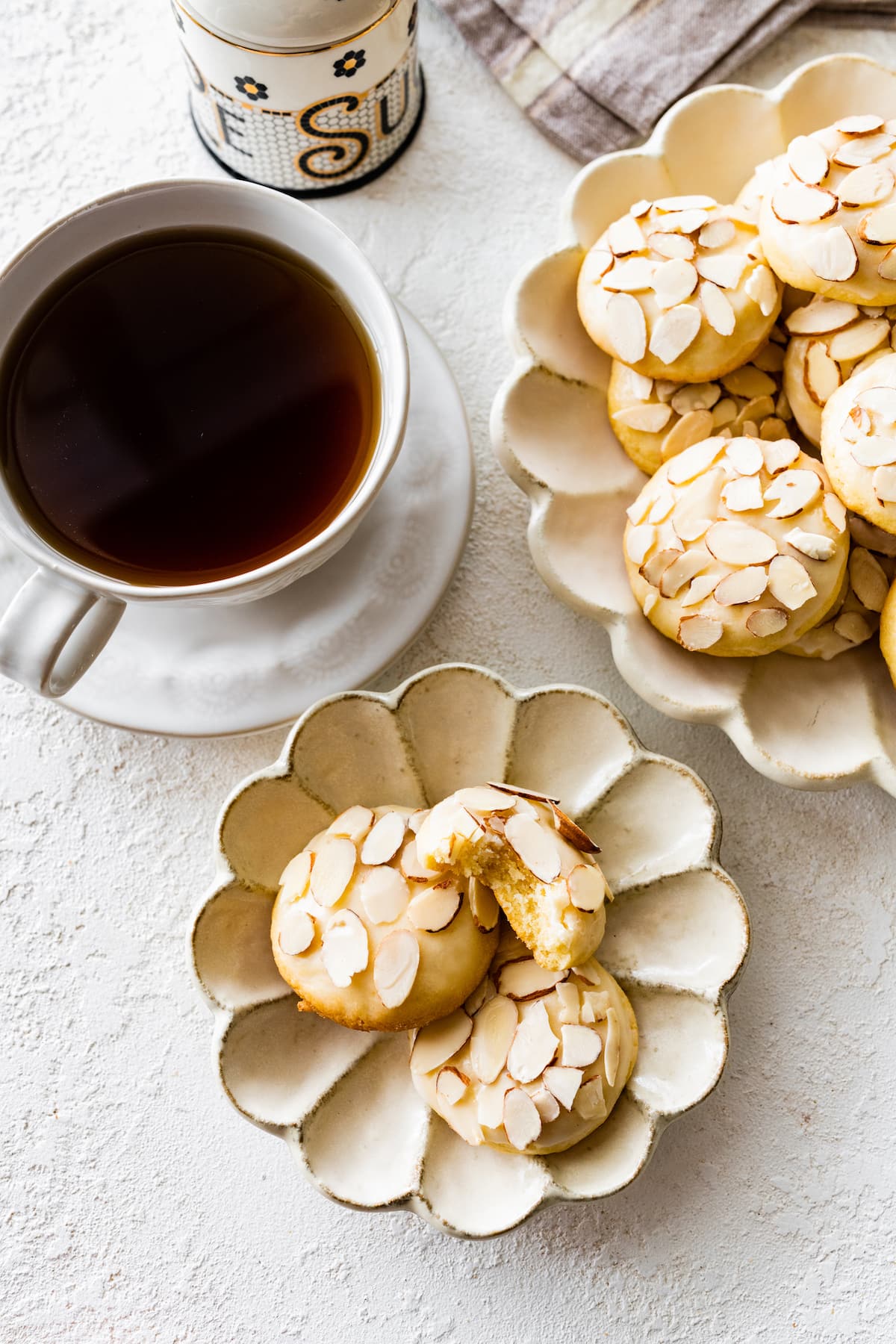 almond cookies on plate with cup of coffee.
