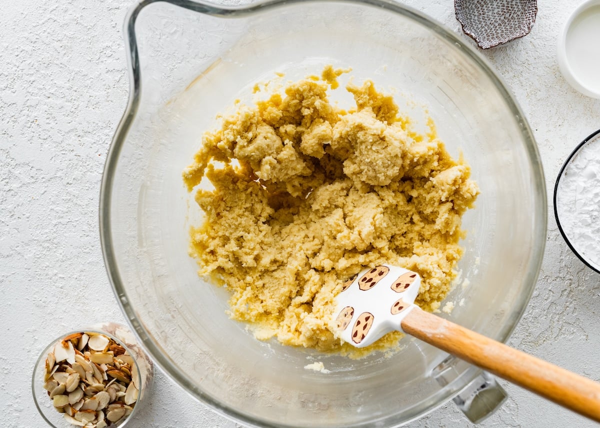 almond cookie dough in mixing bowl with spatula.