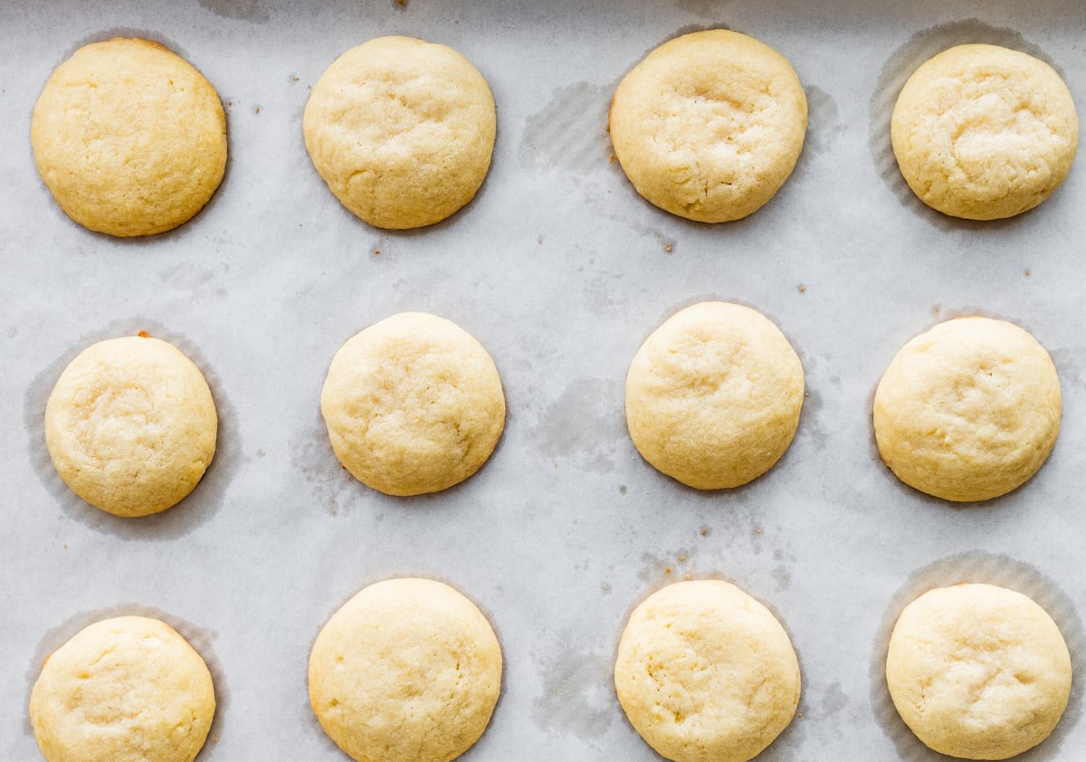 almond cookies on baking sheet with parchment paper.