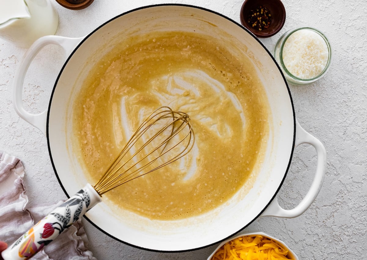 making a roux with a whisk to make broccoli mac and cheese.