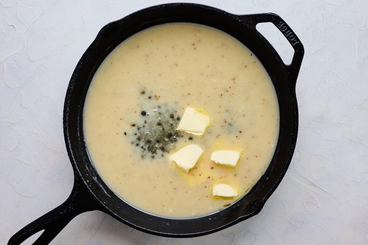 lemon butter sauce with capers in cast iron skillet.