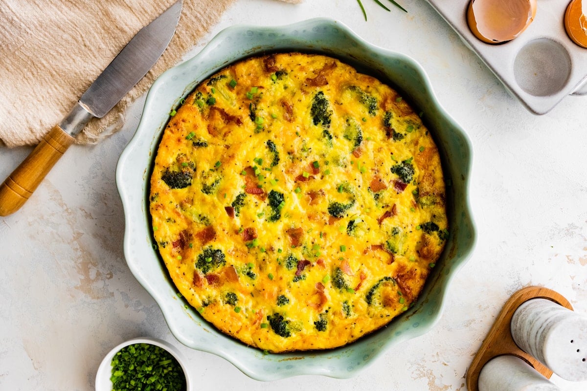 crustless quiche with broccoli, cheddar cheese and bacon in pie pan.