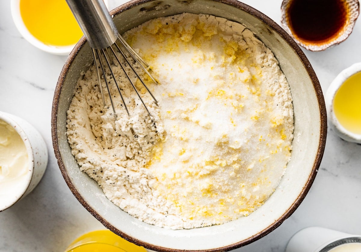 whisking together dry ingredients in mixing bowl to make lemon poppy seed muffins.