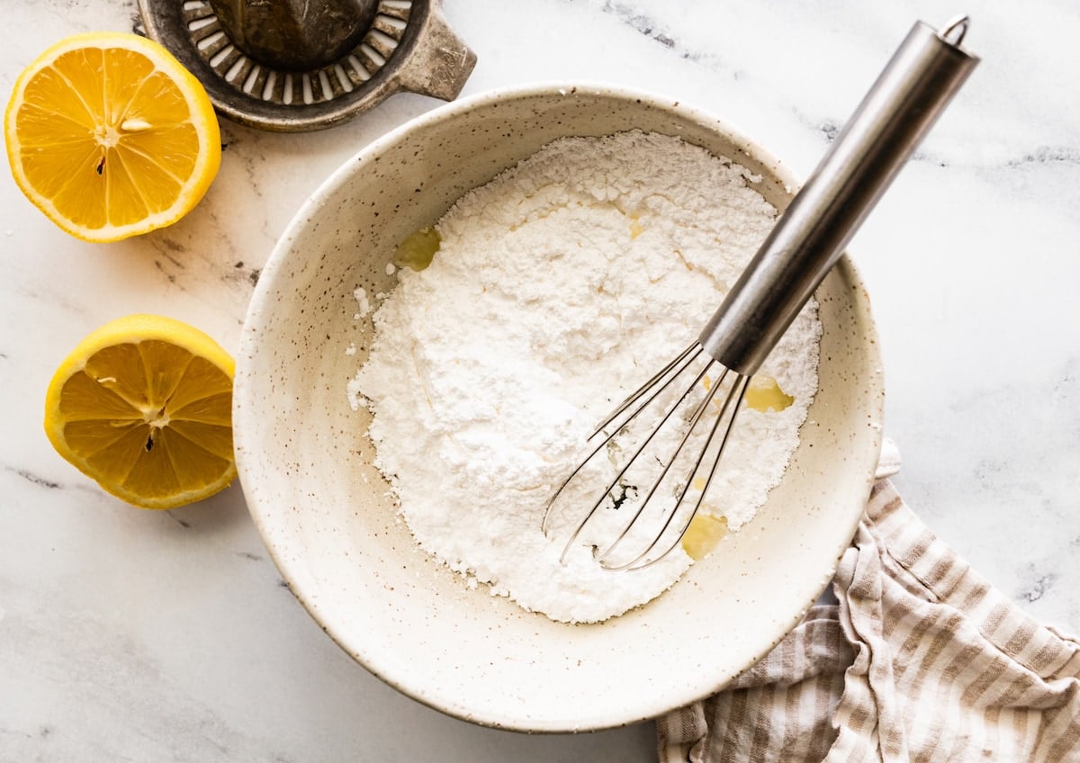 confectioner's sugar and lemon juice in mixing bowl with whisk to make lemon glaze.