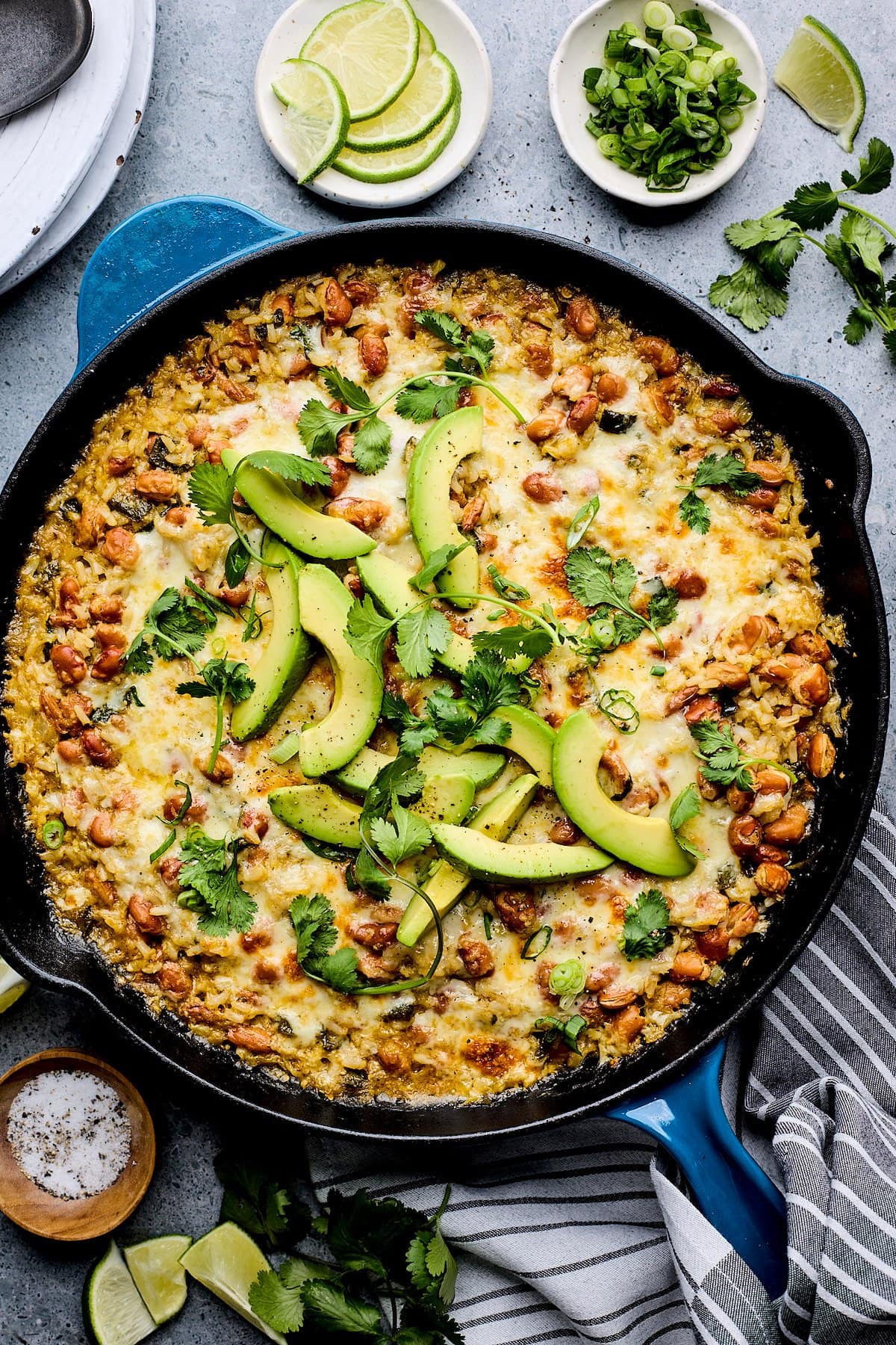 cheesy rice and beak skillet with avocado slices and cilantro.